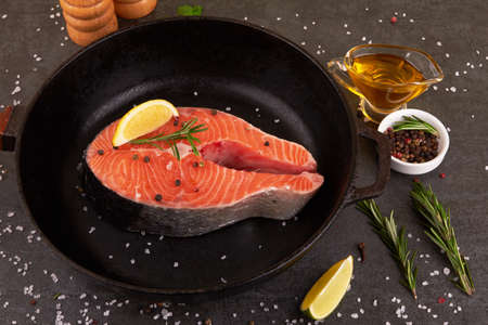 Salmon steak on a pan with spicesの写真素材