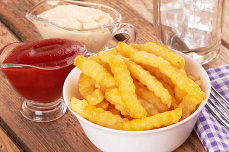 Tasty french fries on wooden table backgroundの写真素材