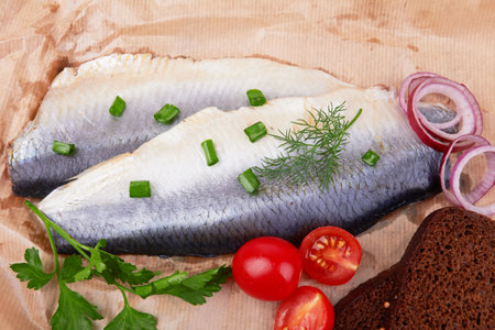 Slices of herring fish isolated on a wooden backgroundの写真素材