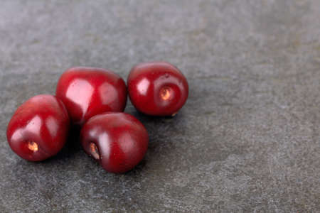 Sweet cherry on a stone black surfaceの写真素材