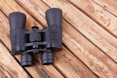 Black binoculars on a wooden surfaceの写真素材