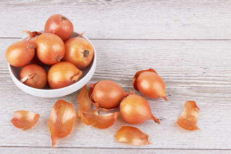 Ripe fresh golden onions on a wooden backgroundの写真素材