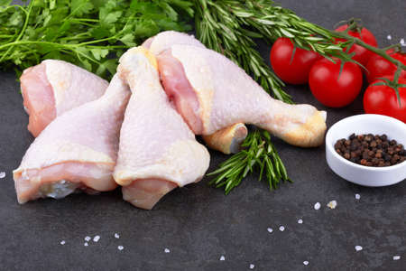 Chicken legs on stone black backgroundの写真素材