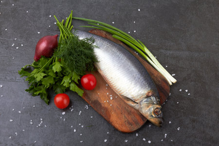 Herring fish on a stone black surfaceの写真素材