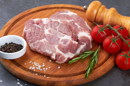 Raw meat with tomatoes on a black surfaceの写真素材