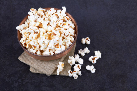 Popcorn in bowl food on black stone backgroundの写真素材