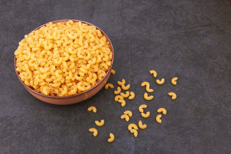 Elbow macaroni on a stone black backgroundの写真素材