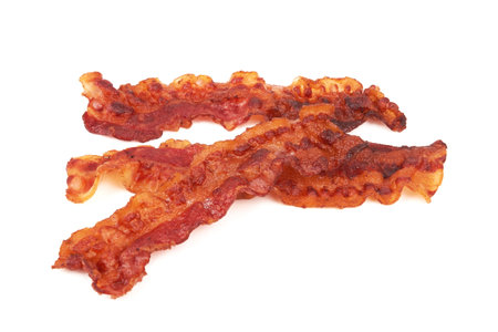 Cooked slices of bacon isolated on whiteの写真素材