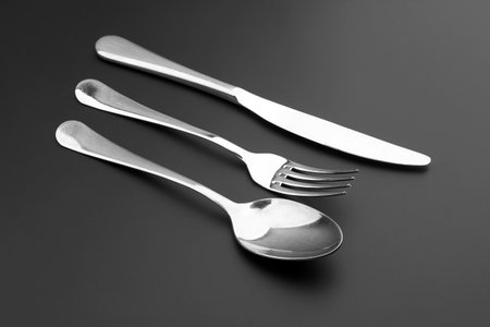 Fork, knife and spoon on black backgroundの写真素材