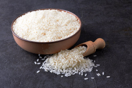 Rice in bowl on black stone backgroundの写真素材