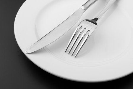 Cutlery with a plate on a dark backgroundの写真素材