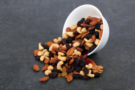 Bowl of mix nuts on black stone surfaceの写真素材