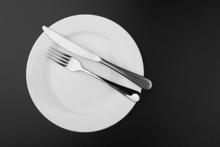 Cutlery with a plate on a dark backgroundの写真素材