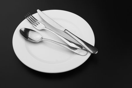 Cutlery with a plate on a dark backgroundの写真素材