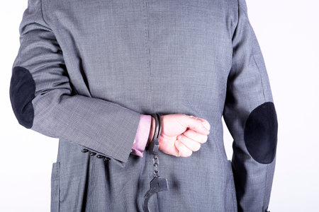 a picture of a businessman locked in handcuffs