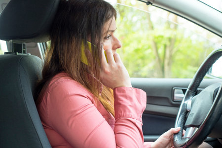 image depicting a woman riding in a car and talking on the phone