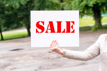 a picture of a woman holding a sale sign in his handの写真素材