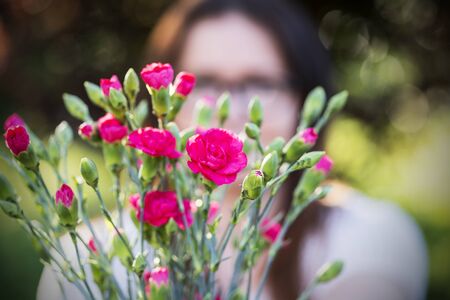 a photo of a young woman with a bouquet of flowersの写真素材