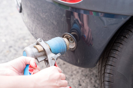 car at gas station being filled with fuelの写真素材