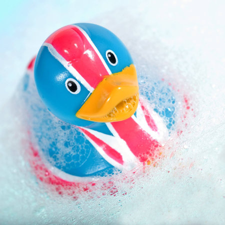 rubber duck against a bubbly blue backgroundの写真素材