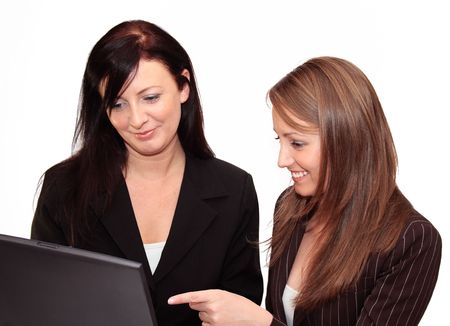 Two young women with laptop isolated on white backgroundの写真素材