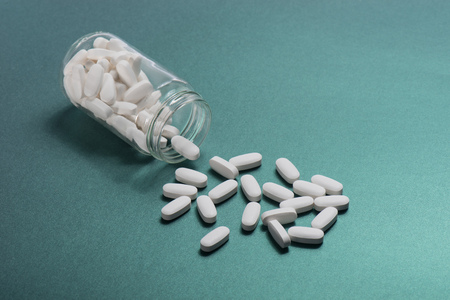 Drug, medicine or supplement pills on table with color effects. Health concept. Medical background.の写真素材