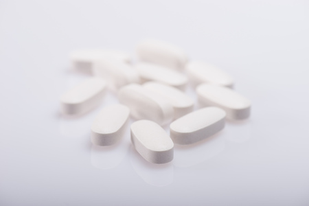 Drug, medicine or supplement pills on table with color effects. Health concept. Medical background.の写真素材