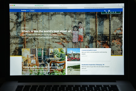 Milan, Italy - August 10, 2017: Booking.com website homepage. It  is a travel fare aggregator website and travel metasearch engine for lodging reservations. Booking logo visible.のeditorial素材