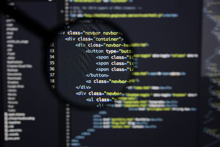 Real Html code developing screen. Programing workflow abstract algorithm concept. Lines of Html code visible under magnifying lens.の写真素材