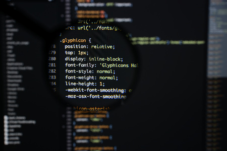 Real css code developing screen. Programing workflow abstract algorithm concept. Lines of css code visible under magnifying lens.の写真素材