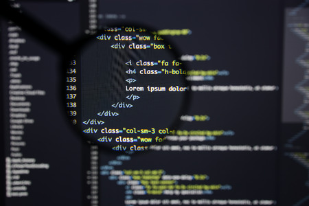 Real Html code developing screen. Programing workflow abstract algorithm concept. Lines of Html code visible under magnifying lens.の写真素材
