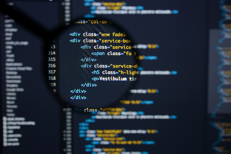 Real Html code developing screen. Programing workflow abstract algorithm concept. Lines of Html code visible under magnifying lens.の写真素材