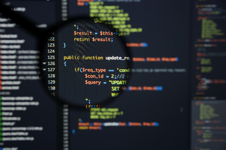 Real Php code developing screen. Programing workflow abstract algorithm concept. Lines of Php code visible under magnifying lens.の写真素材