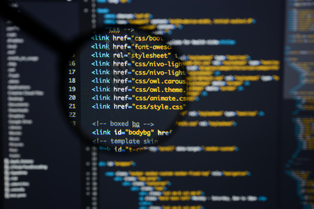 Real Html code developing screen. Programing workflow abstract algorithm concept. Lines of Html code visible under magnifying lens.の写真素材