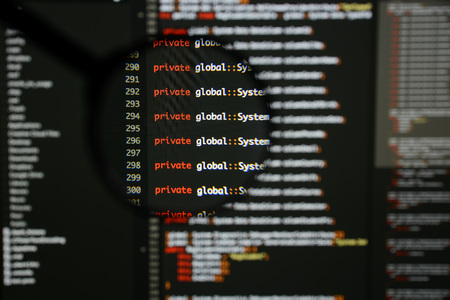 Real c# code developing screen. Programing workflow abstract algorithm concept. Lines of c# code visible under magnifying lens.の写真素材