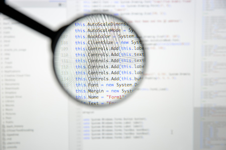 Real c# code developing screen. Programing workflow abstract algorithm concept. Lines of c# code visible under magnifying lens.の写真素材