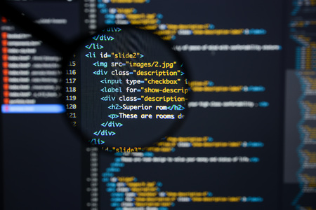 Real Html code developing screen. Programing workflow abstract algorithm concept. Lines of Html code visible under magnifying lens.の写真素材