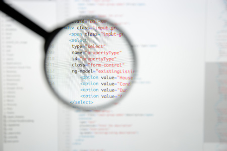 Real Html code developing screen. Programing workflow abstract algorithm concept. Lines of Html code visible under magnifying lens.の写真素材