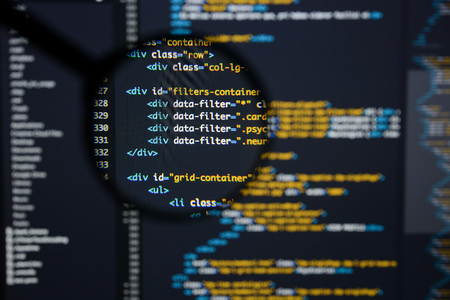 Real Html code developing screen. Programing workflow abstract algorithm concept. Lines of Html code visible under magnifying lens.の写真素材