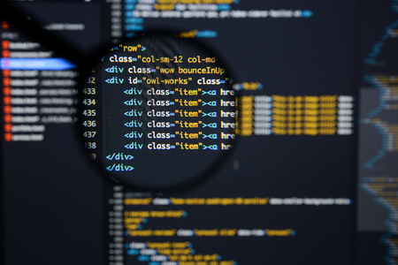 Real Html code developing screen. Programing workflow abstract algorithm concept. Lines of Html code visible under magnifying lens.の写真素材