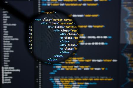Real Html code developing screen. Programing workflow abstract algorithm concept. Lines of Html code visible under magnifying lens.の写真素材