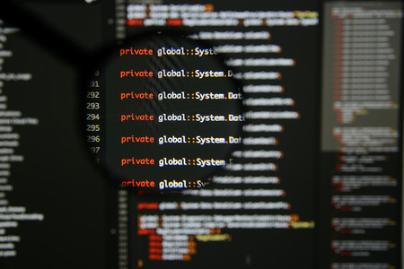 Real c# code developing screen. Programing workflow abstract algorithm concept. Lines of c# code visible under magnifying lens.の写真素材