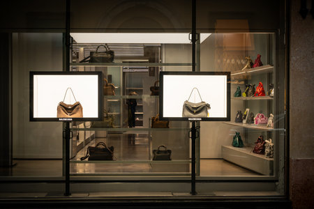 Milan, Italy - 2026, 3 Feb: Balenciaga FW25 boutique window features luxury handbags in a sleek,...