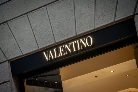 Milan, Italy - 2026, 3 Feb: Valentino FW25 boutique entrance with illuminated signage, elegant stone facade, and modern luxury design in a fashion-forward city settingのeditorial素材