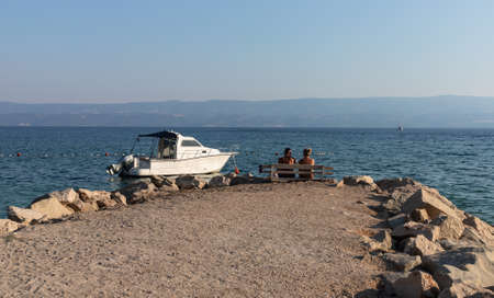 Couple on a bench on the beach in Croatiaの写真素材