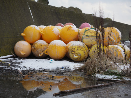 Colourfull buoys and beacons covered with snow on ocean seaside in winter