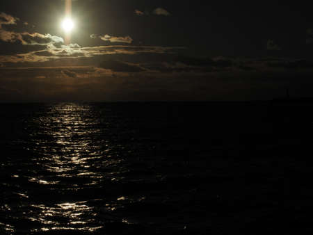 Dramatic sunset over Pacific ocean in winter with sunlight reflecting on waterの写真素材
