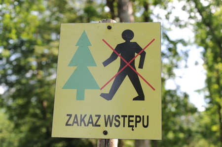 Information sign in Polish âZakaz admuâ, English translation âNo entryâ or âNo trespassingâ with icons of a person and a tree forbidding an entry to the forestの写真素材