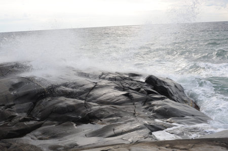 Waves crushing on the rocks at the beach on the sea coast at Jomfruland Island in Norway