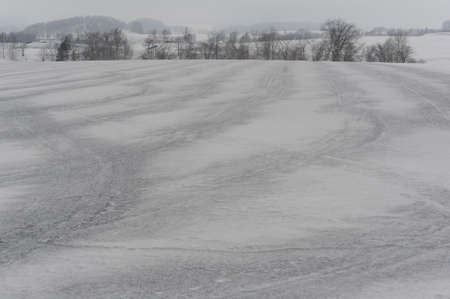 A snowy black and white and grey rural landscape with fields covered with snow in Hokkaido, northern Japan, Asiaの写真素材